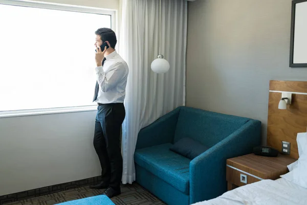Полная Длина Бизнесмен Разговаривает Мобильному Телефону Глядя Окно Гостиничном Номере — стоковое фото
