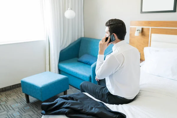 Mannelijke Ondernemer Praten Mobiele Telefoon Terwijl Zittend Bed Hotelkamer — Stockfoto