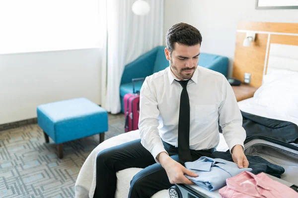 Mid Adult Latin Businessman Packing Clothes Suitcase While Sitting Bed — Stock Photo, Image