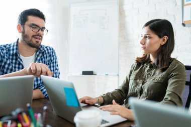 Ofiste laptop üzerinde kadın meslektaşım açıklayan işadamı