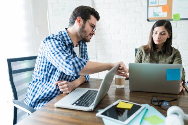 İş yeri insanları dizüstü bilgisayar kullanıyor ve işyerinde masa başında fikirleri tartışıyor