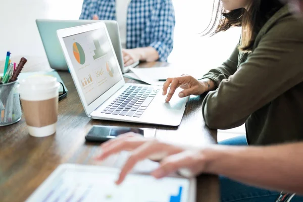 Geschäftsfrau Begutachtet Grafiken Auf Laptop Während Sie Mit Kollegen Schreibtisch — Stockfoto