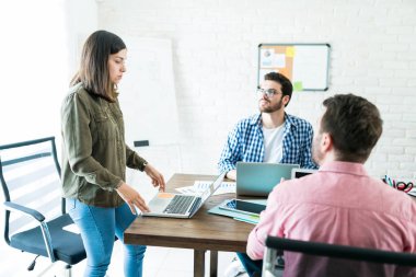 İşkadını ofiste toplantı erkek meslektaşları laptop üzerinden iş planı açıklayan
