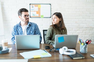 İşyerinde çalışma masasında dizüstü bilgisayarlarda çalışan öfkeli iş ortakları