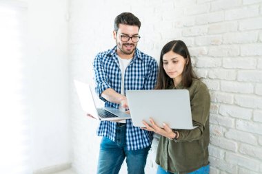 Beyaz işyerinde ayakta iken laptop üzerinden tartışmak iş arkadaşları