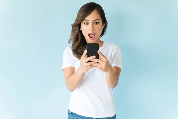 Geschokt Vrouw Kijken Naar Mobiele Telefoon Terwijl Staan Tegen Blauwe — Stockfoto