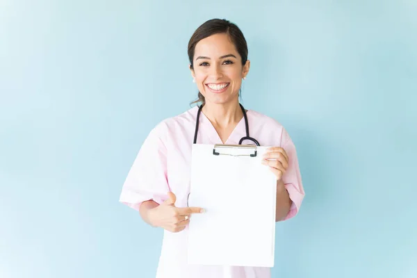 Sonriendo Hermoso Profesional Médico Mostrando Portapapeles Aislado Sobre Fondo Liso —  Fotos de Stock