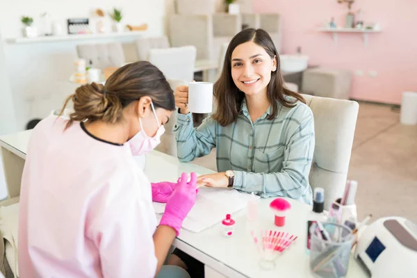 Sonriente Cliente Joven Tomando Café Mientras Hace Las Uñas Salón —  Fotos de Stock