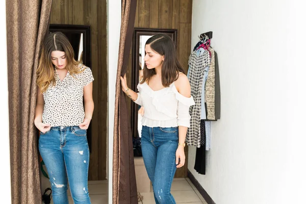 Young Woman Looking Female Friend Wearing New Top While Standing — Stock Photo, Image