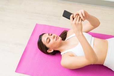 Mobil mesajlaşma sırasında rahatlatıcı güzel esmer Kafkas kadın yüksek açı görünümü