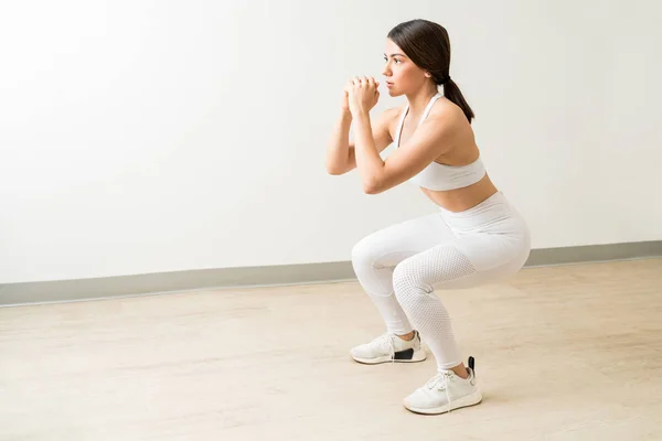 Toute Longueur Belle Brune Qui Fait Des Squats Sur Parquet — Photo