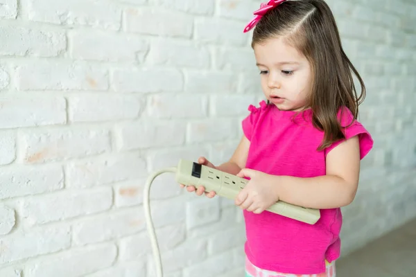 Schattig Klein Meisje Kijkend Naar Extensie Snoer Door Muur Woonkamer — Stockfoto