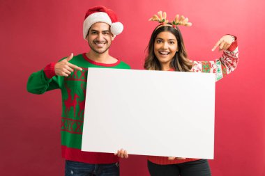 Kırmızı arka plan aleyhine işaret ederken güzel kadın ve adam boş pankart tutarak