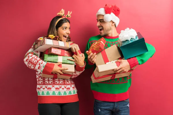 Cheerful Young Couple Holding Christmas Presents Red Background — Stock Photo, Image