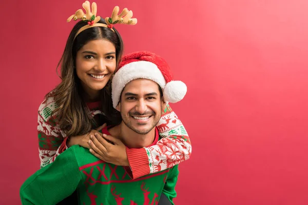 Smiling Hispanic Attractive Man Carrying Woman While Celebrating Christmas Isolated — Stock Photo, Image