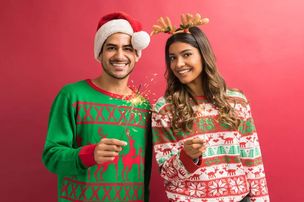 Smiling Young Attractive Couple Holding Sparklers While Enjoying Christmas Studio — Stock Photo, Image