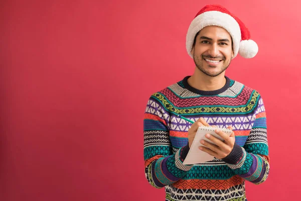 Portret Uśmiechnięty Atrakcyjny Mężczyzna Przygotowuje Listę Xmas Notatniku Studio — Zdjęcie stockowe