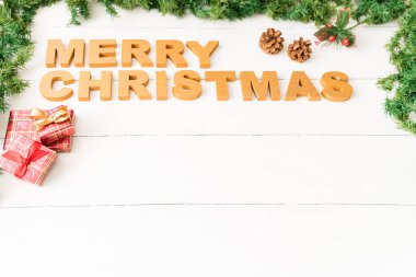 Bazı süslemeleri ve kopya alanı ile ahşap bir masa üzerinde oturan Merry Christmas mesajı yüksek açı görünümü