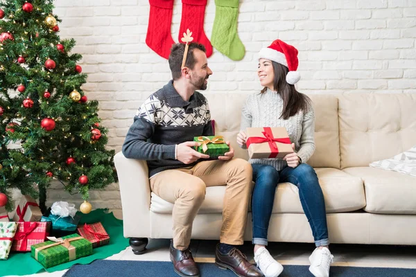 自宅でクリスマスプレゼントを交換する笑顔の中大人のカップル — ストック写真