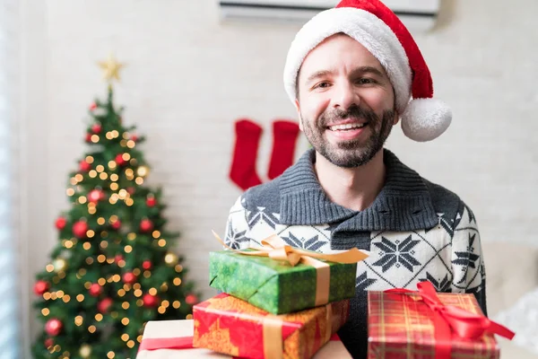 Noel Zamanı Evde Hediye Kutuları Tutan Santa Hat Giyen Gülümseyen — Stok fotoğraf