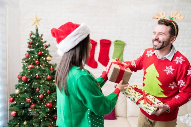 Mutlu çift Noel kutlamaları sırasında evde hediyeler takas