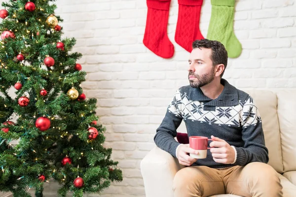 Düşünceli Huysuz Adam Evde Noel Ağacı Tarafından Bakarken Kahve Sahip — Stok fotoğraf