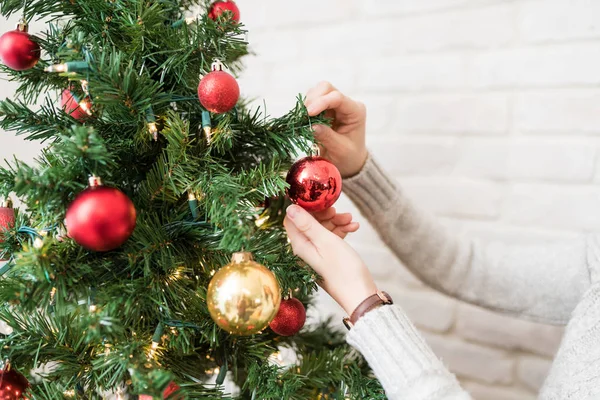 집에서 반짝이는 장식으로 크리스마스 트리를 장식하는 여성의 — 스톡 사진