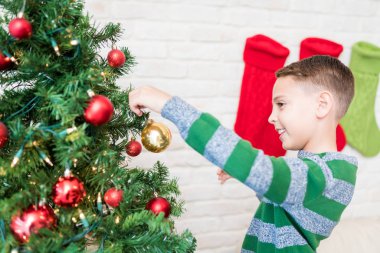 Evde Noel ağacı dekorasyon gülümseyen çocuk Yan görünümü