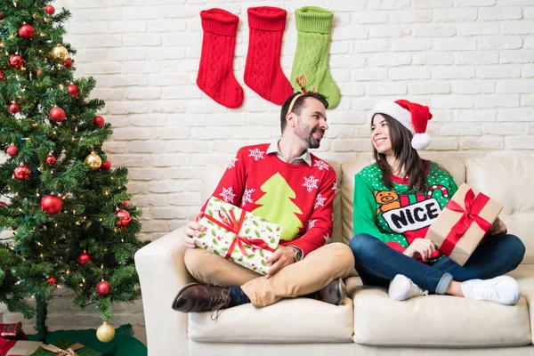 Happy Couple Ugly Sweater Gifts Sitting Sofa Home Christmas Time — Stock Photo, Image