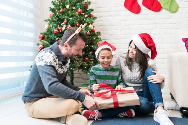 Lyckliga Föräldrar Med Upphetsad Son Tittar Julklapp Vardagsrummet — Stockfoto