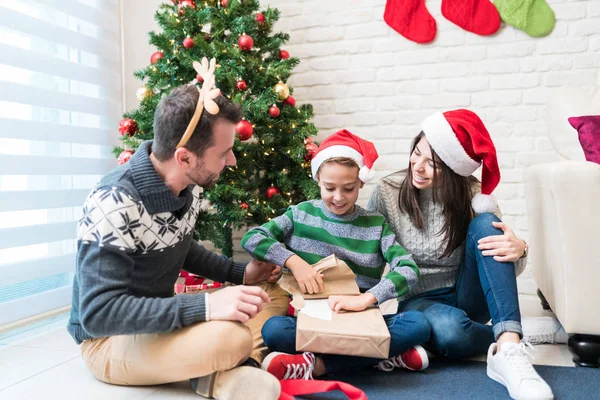 Lyckliga Föräldrar Med Upphetsad Son Tittar Julklapp Vardagsrummet — Stockfoto