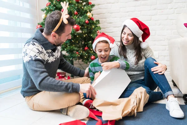 Lyckliga Föräldrar Med Upphetsad Son Tittar Julklapp Vardagsrummet — Stockfoto