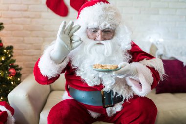 Noel baba Noel sırasında evde kanepede otururken onun çerezleri zevk