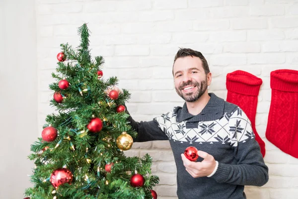 Evde Süsler Ile Noel Ağacı Süsleyen Iyi Görünümlü Adam — Stok fotoğraf