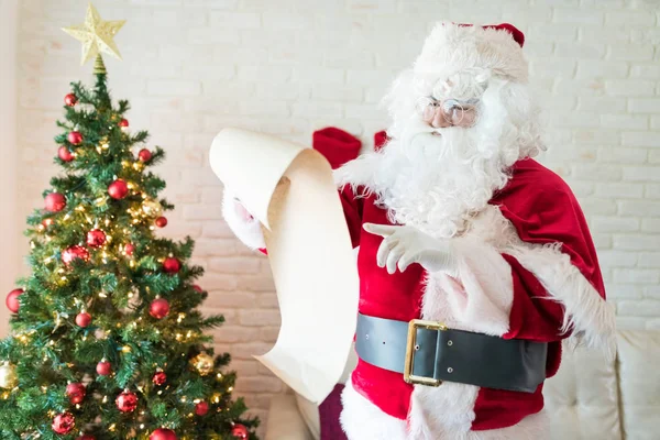 Santa Claus Sprawdzanie Lista Chwila Stojący Przy Choinka Dom Podczas — Zdjęcie stockowe