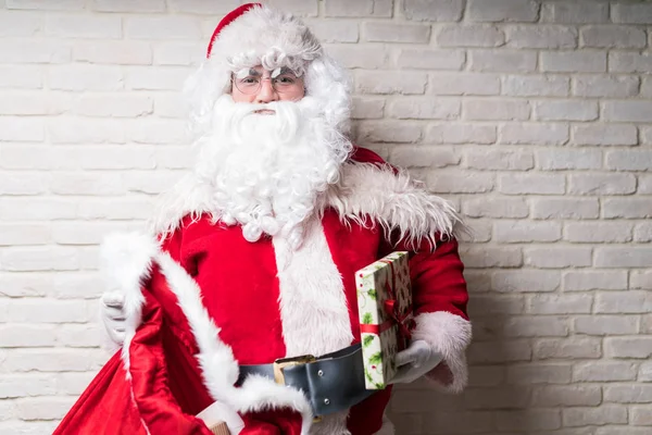 Mężczyzna Ubrany Santa Kostium Trzyma Worek Boże Narodzenie Prezent Ścianie — Zdjęcie stockowe