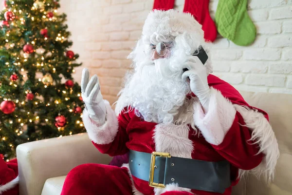 Święty Mikołaj Białą Brodą Rozmawiać Smartphone Patrząc Kartę Kredytową Podczas — Zdjęcie stockowe