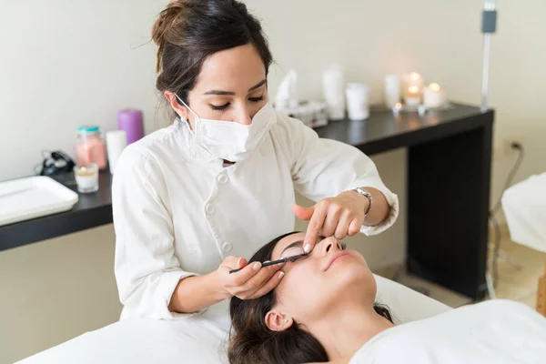 Mulher Caucasiana Cosmetician Escovação Pestanas Cliente Hispânico Centro Saúde — Fotografia de Stock