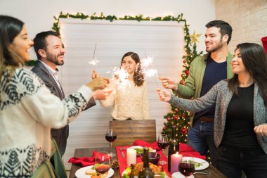 Mutlu arkadaşlar şenlik partisinde evde maytaplarla Noel yemeğinin keyfini çıkarıyorlar.