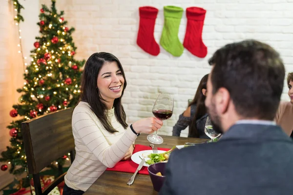 在家里的圣诞晚宴上和男人聊天时 微笑着喝红酒的中年女人 — 图库照片