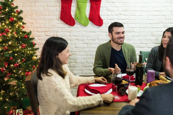 圣诞晚会期间 快乐的朋友们在餐桌边聊天 — 图库照片