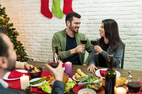 Paar Prostet Weingläser Während Das Weihnachtsessen Mit Freunden Hause Genießt — Stockfoto