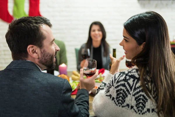 Mosolygó Barátok Beszélgetnek Miközben Élvezi Italok Vacsora Party Otthon Karácsonykor — Stock Fotó