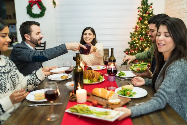 Boldog Barátok Élvezi Étkezés Asztalnál Házban Karácsonyi Ünnepségek Alatt — Stock Fotó