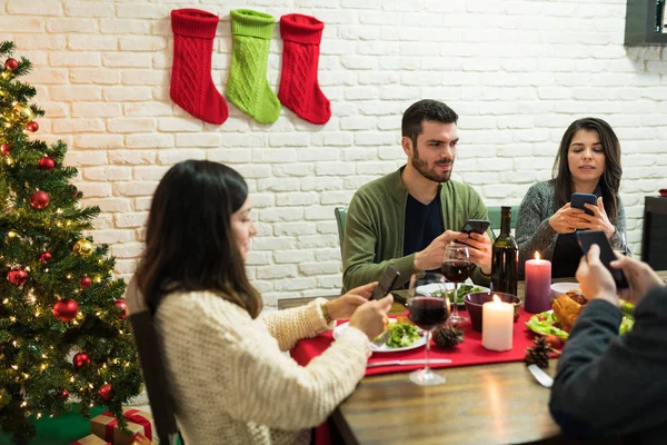 Amigos Socializando Teléfonos Móviles Mientras Ignoran Mutuamente Durante Cena Navidad —  Fotos de Stock