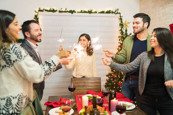 Happy Friends Enjoying Christmas Dinner Sparklers Home Festive Party — Stock Photo, Image