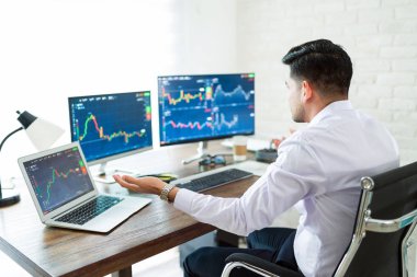 Bilgisayar ekranındaki grafiklere bakarken serbest çalışan bir borsa simsarıydı.