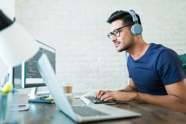 Evden çalışırken yakışıklı genç erkek yazılım geliştirici programlama kodları