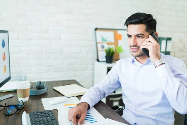 Snygg Manlig Försäljning Frilansare Talar Mobiltelefon Medan Sitter Vid Skrivbordet — Stockfoto