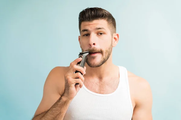 스페인의 남자가 청록색 배경에 맞추면서 면도칼로 콧수염을 — 스톡 사진